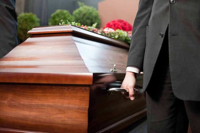 shutterstock_113984353 Pallbearer holding a wooden casket handle