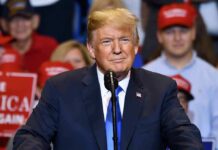 Donald Trump speaking at a rally podium