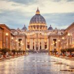 St. Peter's Basilica at the end of a wet street at dusk