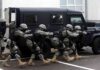 Haiti Gangs Targeting Foreign Troops Tactical team advances beside an armored vehicle