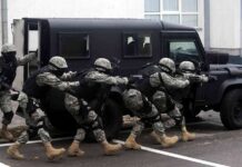 Haiti Gangs Targeting Foreign Troops Tactical team advances beside an armored vehicle