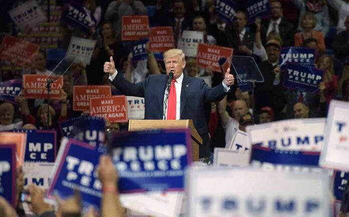 Donald Trump speaks at a rally, giving two thumbs up