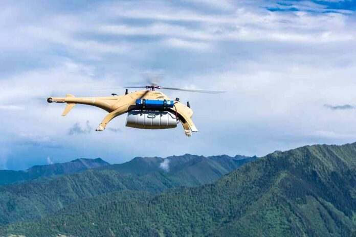 shutterstock_1432154513 Cargo drone helicopter flying over green mountain range