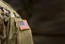 Teen Sues Marine Corps After Six-Hour Sexual Assault american flag patch on camouflage uniform sleeve