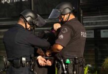 Trans Sex Workers CLASH With City Police Police officers handcuff a person during an arrest