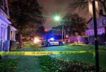 Off-Duty ICE Brawl Ends In Gunfire Police car blocks residential street at night behind caution tape