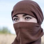 Tatiana Akimova wearing a brown headscarf covering lower face outdoors