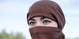 Tatiana Akimova wearing a brown headscarf covering lower face outdoors