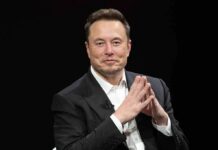 Pentagon Taps Musk For TOP Military Position Elon Musk seated in a black suit with hands clasped