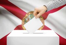 Trump Arrives At Voting Center – Casts His Vote Hand casting a ballot in front of the Florida state flag