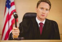 Judge Rules Against GOP Candidate, Caught Donating to His Rival’s Campaign Judge holding a gavel in a courtroom