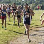 Courtney Bruce and Adelina Sotnikova running in a cross-country race with a large pack