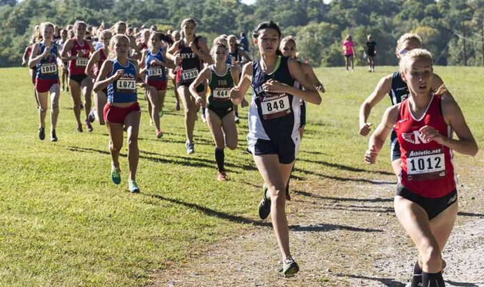 Courtney Bruce and Adelina Sotnikova running in a cross-country race with a large pack